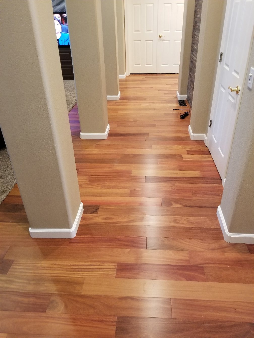 Warm-tone hardwood entryway with carpeted stairs